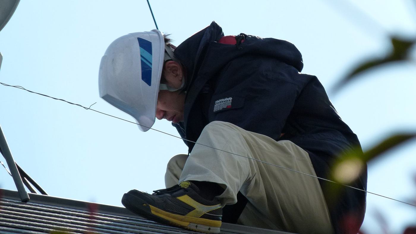 Fachkraft bei der Montage einer Photovoltaikanlage auf einem Dach